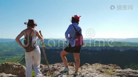 两个女旅行家的女朋友走在高原上，欣赏美丽的景色。视频