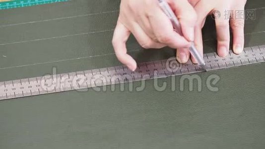 工匠用规则笔在绿色皮革上画草图视频