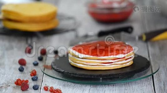 女性糕点厨师用旋转蛋糕制作美味的海绵蛋糕、鲜奶油和浆果果酱视频