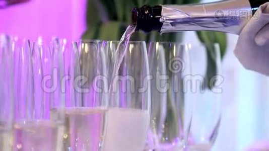 宴会上的侍者把香槟倒入玻璃杯中。视频