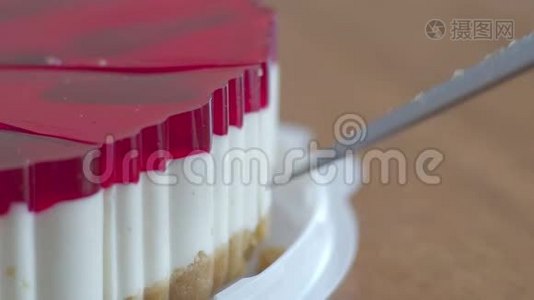 从蛋糕上切下的一块水果芝士蛋糕放在镜头前。 蛋糕上装饰着一片片视频