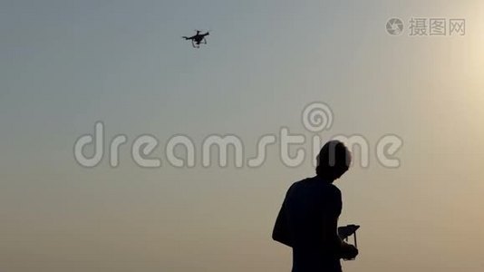 聪明的人在太阳落山时用面板控制他的飞行无人机视频
