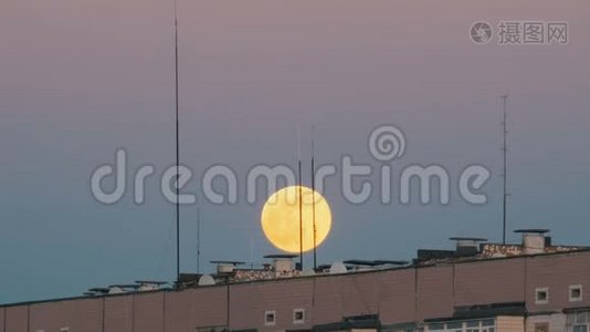一栋多层建筑屋顶上方的满月正在上升视频