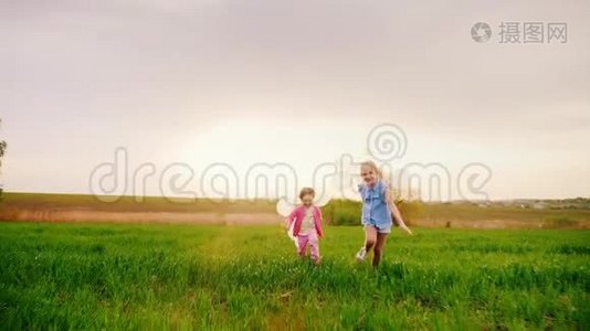 两个无忧无虑的带着气球的小女孩.. 在日落的时候在绿茵场上奔跑吧。 快乐的童年，梦想视频