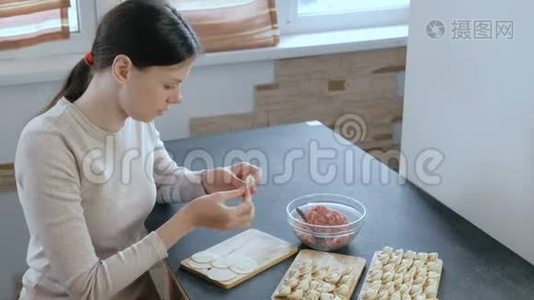 女人用肉馅包饺子。 侧视。视频