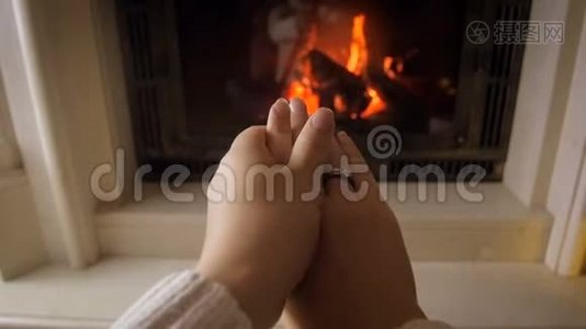 在寒冷的冬日，一位年轻女子因燃烧着的火而暖手的特写镜头视频