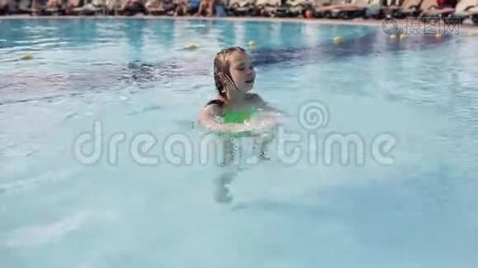 一个小女孩在避暑胜地的游泳池里游泳视频