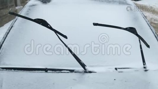 把车停在前面，挡风玻璃雨刷在冬天远离被雪覆盖的窗户视频