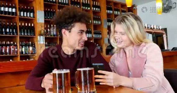 一对夫妇在喝啤酒的时候用手机视频
