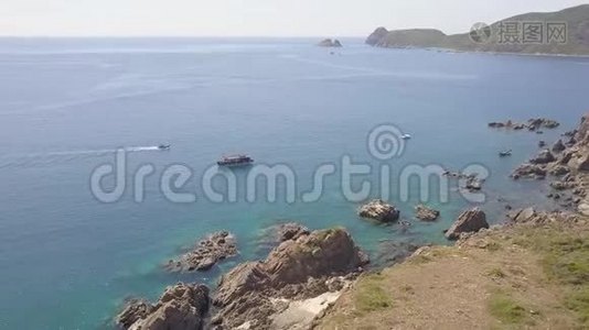 帆船在蓝色海水和岩石悬崖鸟瞰。 无人驾驶帆船在海湾和山崖上航行视频