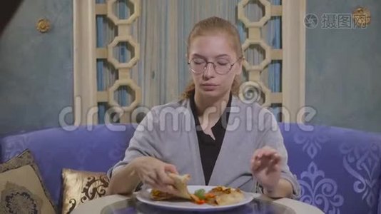 戴眼镜的年轻女孩在一家东方餐馆吃肉饼视频