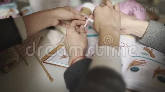 两姐妹一起学着用编织图案编织。编织手视频