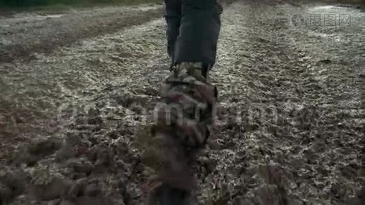 穿军靴的男腿在肮脏的道路上行走视频