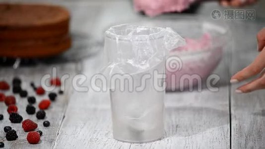 糖果商把奶油从立式搅拌机放进烹饪袋。视频