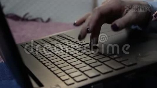 一个年轻女孩在笔记本电脑上打字的手。视频