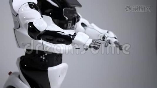 现代机器人技术。 白色现代机器人在一个明亮的工作室。 安卓舞，挥舞着手臂.. 示范视频
