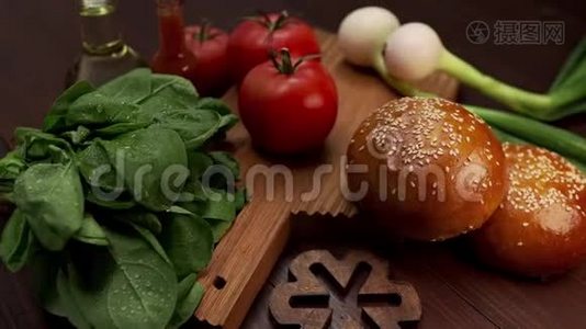 视频展示制作美味汉堡、新鲜蔬菜和烹饪用蔬菜、芝麻面包的配料视频
