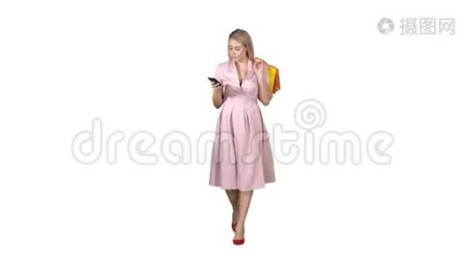 购物妇女带着袋子，在智能手机上发短信，而在白色背景下行走。视频