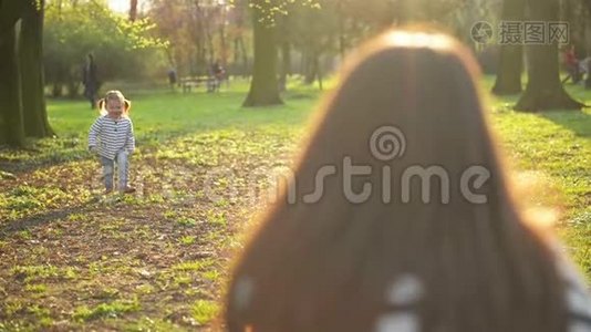 有趣的小女孩正在享受阳光天气与母亲一起度过空闲时间户外。 漂亮女儿在跑步视频