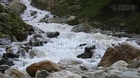 慢动作的水从一块巨大的岩石上掉下来。 阴天有小雨的自然环境中的瀑布视频