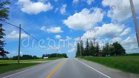在明亮的夏日驾驶农村。 沿着美丽的阳光路的司机视角视频