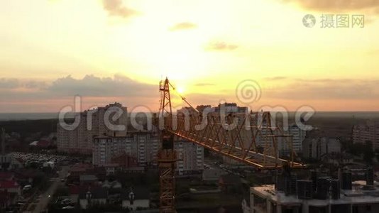 一台建筑起重机在风中迎着清晨的天空微微摇曳。 特写、空中录像视频