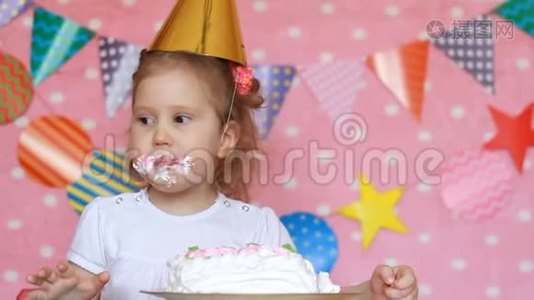 生日快乐。 一个可爱的小女孩吃一个脏脸和脏手的蛋糕。视频