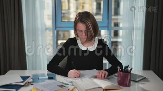 心烦意乱的女学生正在读一本书，并在练习本中写作。 它会很沮丧，会搞清楚视频