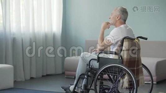 可怜的孤独老人坐在轮椅上的养老院里视频