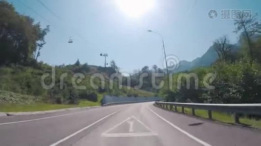 从缆车上行驶在高速公路上，在缆车下被乔灌木覆盖的美丽山脉上的景色视频