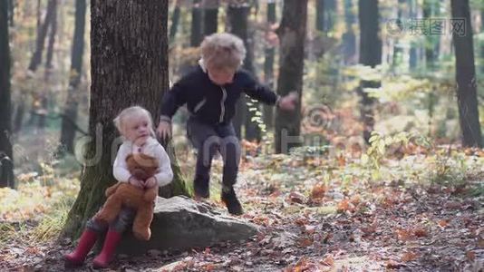 快乐的小孩子，小女孩在秋天嬉笑打闹，在大自然的户外散步视频