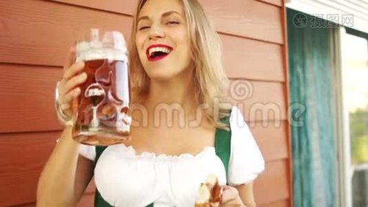 一个女人急切地从一个大玻璃杯里喝啤酒。 在音乐节十月节，德国民族传统视频