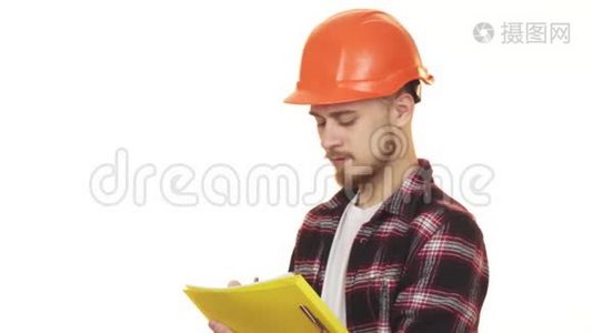 年轻的专业男承包商在哈达帽上微笑着做笔记视频
