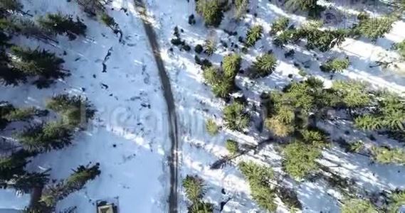 冬季乡村道路在雪林，鸟瞰无人机在4k。视频