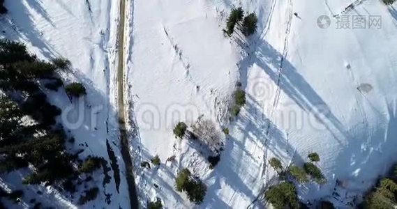 冬季乡村道路在雪林，鸟瞰无人机在4k。视频