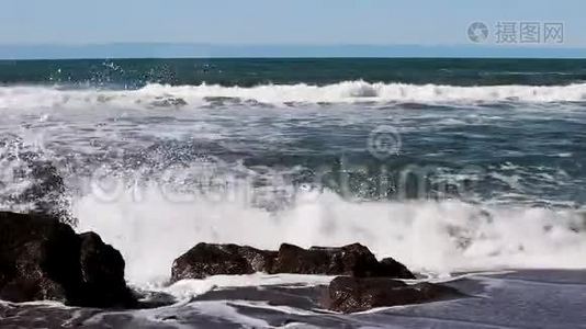 海浪冲击沙滩冲浪者的岩石背景视频