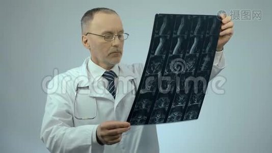 严重的医生检查受伤的脊柱扫描图像，看相机视频