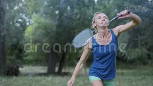 美丽的微笑，运动健身女子在公园打羽毛球。视频