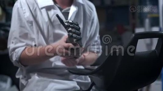 一位科学家工程师正在测试一种电子仿生假肢。 他用机械手臂的塑料手指视频