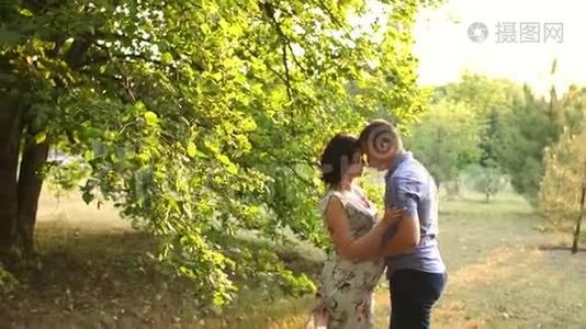 丈夫温柔地拥抱和亲吻怀孕的妻子。视频