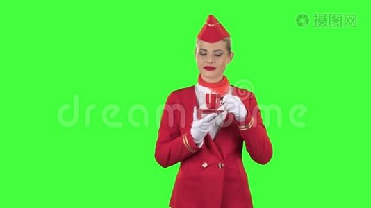 戴手套的女服务员用红色杯子喝咖啡。 绿色屏幕视频