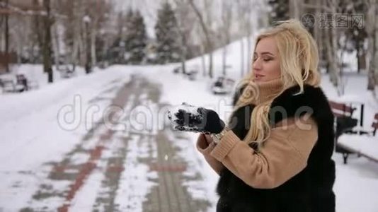 冬天的女孩在公园里吹雪。 特写镜头。视频