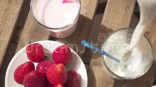慢动作草莓和巧克力牛奶放在杯子旁边，然后倒入牛奶视频