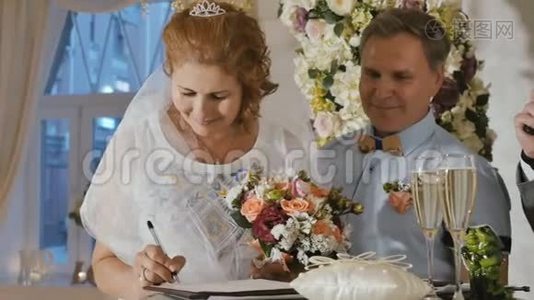 快乐的成年新娘签署结婚证书视频