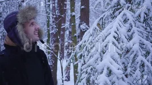 快乐的人走在白雪覆盖的寒冷的冬天森林里视频