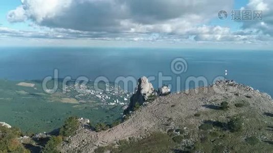 宁静的草地和从山上看海的城市。 中枪。 海洋景观空中视频