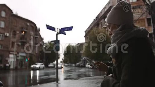 小镇上一个下雨天晚上，一个年轻的女人在街上用手机视频