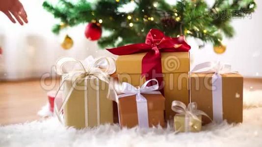 手拿圣诞树下的礼品盒视频
