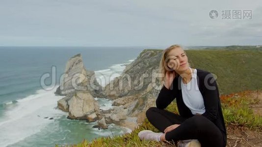 在葡萄牙的Cabo da Roca，年轻女子欣赏海景。视频