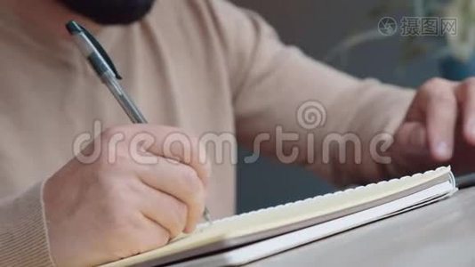 穿浅色毛衣的人用黑色钢笔在笔记本上写字，特写..视频